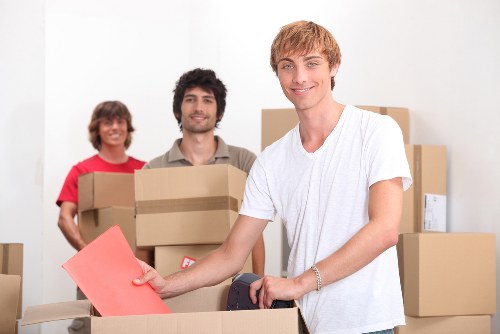 Professional movers handling packed boxes and furniture for a local move